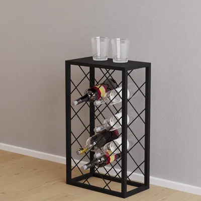 A black metal wine rack with bottles of wine and two glasses on top, placed on a wooden floor against a light gray wall.