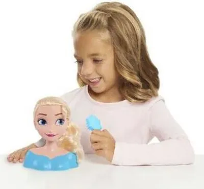 A young girl is playing with a Disney Princess Elsa Mini Styling Head.