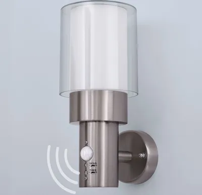 A modern outdoor wall light with a motion sensor, mounted on a light blue wall.