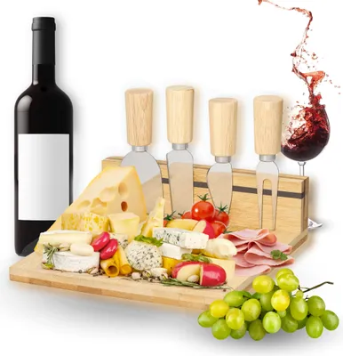 A cheese board set with various cheeses, meats, grapes, tomatoes, and cheese knives, along with a bottle of red wine and a splash of wine in a glass.