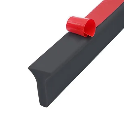 A close-up of a gray sealing strip with red adhesive tape being peeled off.