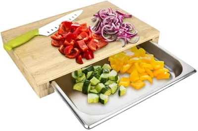 A cutting board with chopped vegetables and a knife.