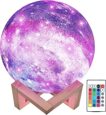A galaxy-themed LED moon lamp on a wooden stand, with a remote control visible.