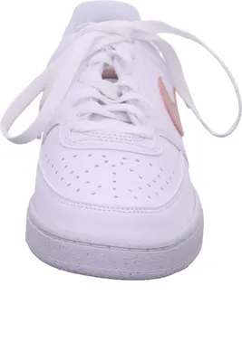A close-up, front-facing view of a white Nike sneaker with a pink swoosh.