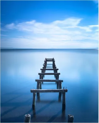 Produktbild von Wallario Poster - Rustikaler Holzsteg im blauen See, Kunstdruck Größe: 40 x 50 cm
