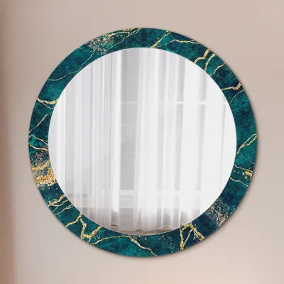 A round mirror with a teal and gold marble-like frame is displayed on a light beige wall.