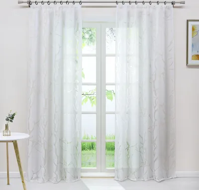 A white sheer curtain with a subtle leaf pattern hangs in front of a window.