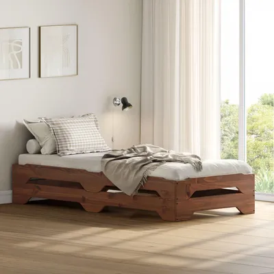 A wooden bed with bedding in a room with curtains and artwork.