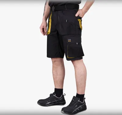 A person wearing black cargo shorts and black shoes, shown from the side.