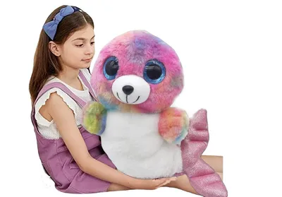 A young girl is holding a large, colorful plush toy seal.