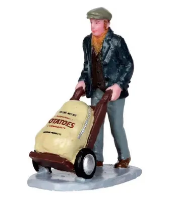 Ein Mann der einen Sack Kartoffeln auf einem Handwagen schiebt. Er trägt Mütze, Jacke und eine Weste