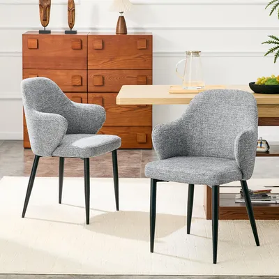Productafbeelding van Set van 2 grijze stoelen met stoffen bekleding. Hoogte 83 cm, met kruisvormige metalen poten voor extra stabiliteit. Eetstoelen met een brede, omhullende rugleuning. Kleuren: zwart, grijs