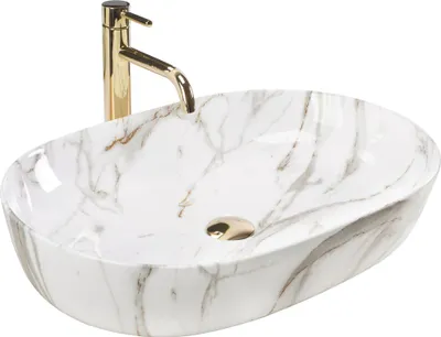 A white oval countertop sink with a marble pattern and a gold faucet.