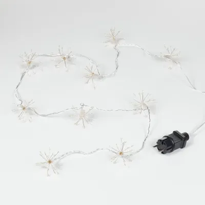 A string of white snowflake-shaped lights with a black power plug on a white background.