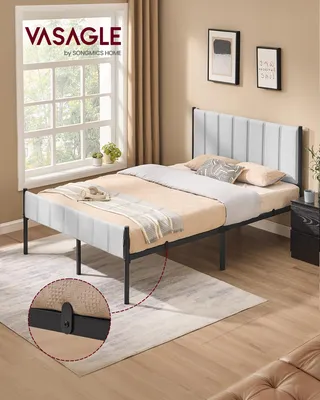 A bedroom scene with a bed, nightstand, and artwork on the wall.