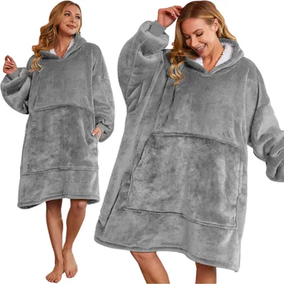 Two women wearing oversized grey hoodie blankets.