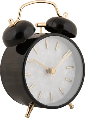 A close-up studio shot of a black alarm clock with a pearl-like face and gold accents.