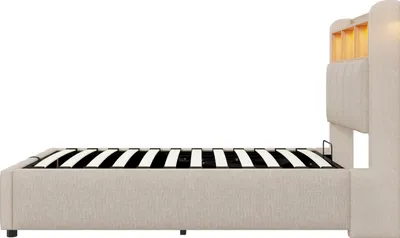 Side view of a beige upholstered bed frame with a slatted mattress support.
