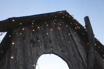 Close-up of wooden structure with string lights.