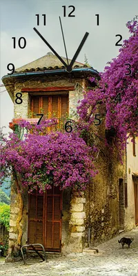 Produktbild von Wallario Design Wanduhr Malerische Stadt in der Provence mit bunten Blumen aus Echtglas, Größe 30 x 60 cm