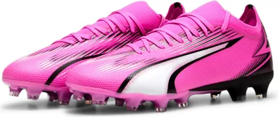 A pair of pink Puma soccer cleats on a white background.