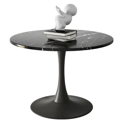A round black marble table with a dark pedestal base, featuring a small white sculpture of a baby on top of two books.