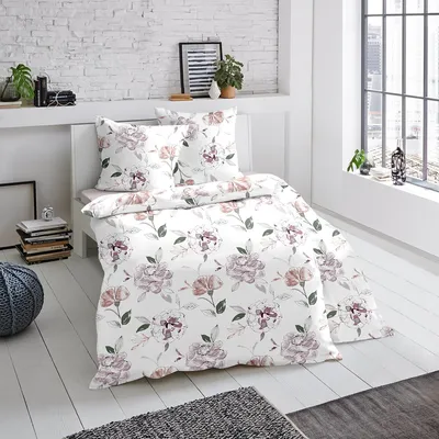 A bed with floral patterned bedding in a bright, modern room.