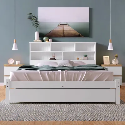 A bedroom scene featuring a white bed with a bookshelf headboard, nightstands, and wall art.