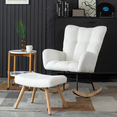 A white fluffy rocking chair and ottoman are placed in a living room setting with a side table and a cabinet in the background.
