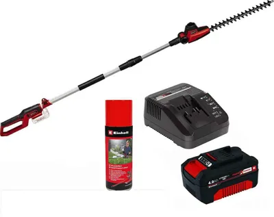 A collection of garden power tools including a hedge trimmer, battery charger, battery pack, and a can of lubricant spray.