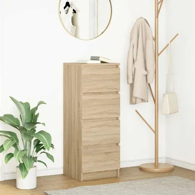 A tall, narrow wooden dresser with four drawers stands against a white wall. A large green plant is to the left, and a coat rack with a coat and bag is to the right. A round mirror hangs on the wall above the dresser.