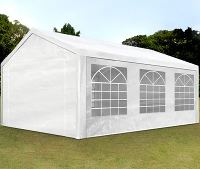 A white party tent with arched windows is set up on a grassy lawn with trees in the background.
