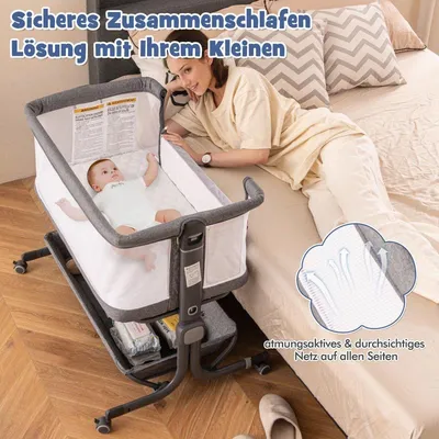 A woman is lying on a bed next to a baby bassinet where a baby is sleeping. The bassinet is attached to the bed.