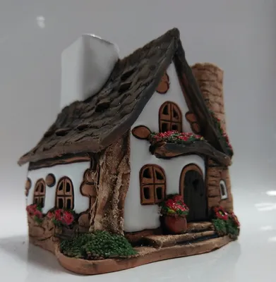 Ein handgefertigtes Haus in weiß verputzt und hat ein braunes Ziegeldach. Detailreich gestaltet.