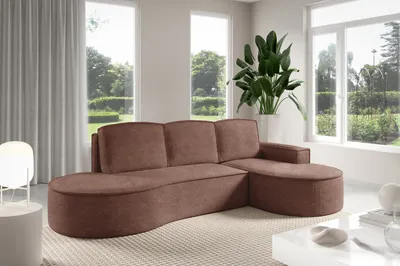 A modern living room with a large sectional sofa in front of large windows overlooking a garden.