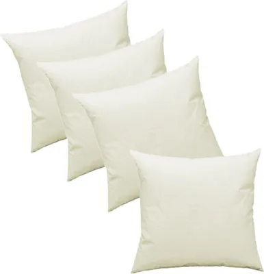 A group of four white pillow inserts arranged diagonally on a white background.