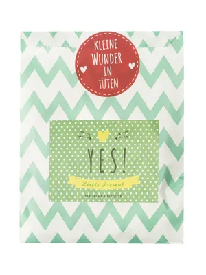 A gift bag with a chevron pattern and polka dots, featuring text.