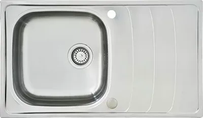 A top-down view of a stainless steel sink with a drain and a ribbed draining board.