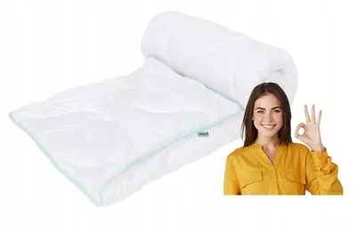 A rolled-up white duvet is shown next to a woman giving a thumbs-up gesture.