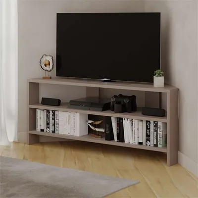 A corner TV stand with a TV, game console, and books.