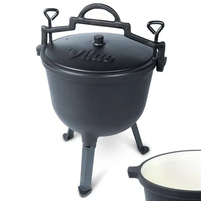 A black cast iron cauldron with a lid and three legs, shown against a white background. A portion of another similar item is visible in the lower right corner.