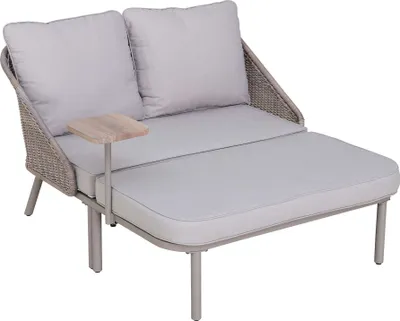 An outdoor daybed with cushions and a small side table.