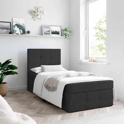 A bedroom scene with a single bed, shelf with artwork, and a window.