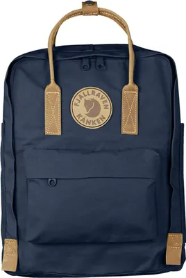 A close-up studio shot of a blue backpack with tan leather accents.