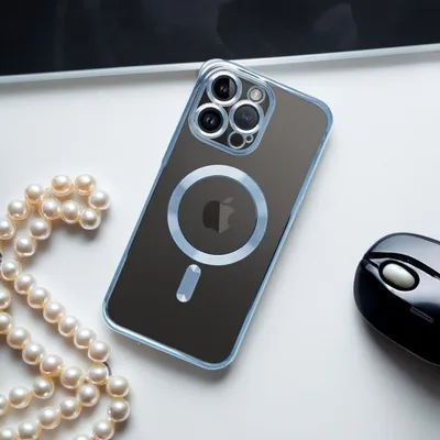 A clear, well-lit shot of an iPhone case on a white surface, with a strand of pearls and a computer mouse visible.