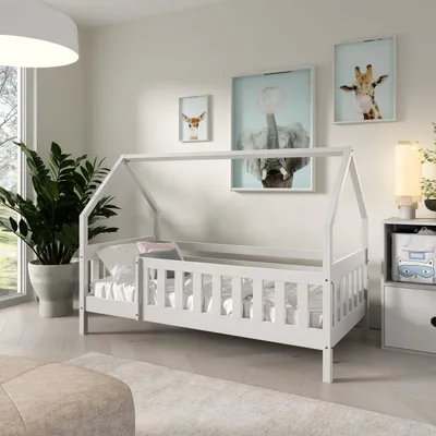 A child's bedroom with a white house-shaped bed, a large potted plant, and animal-themed artwork on the wall.