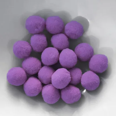 A pile of small, fluffy purple pom-poms in a white bowl.