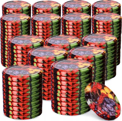 Stacks of metal jar lids with a fruit mix pattern.