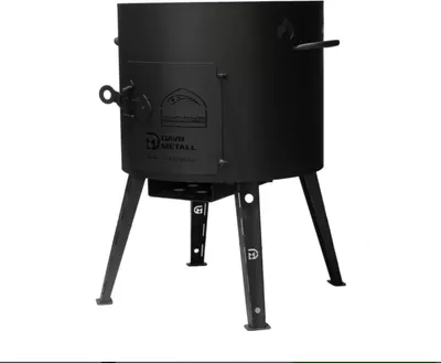 A black metal outdoor stove with three legs and a door.