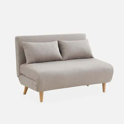 A beige sofa with two pillows on a light gray background.
